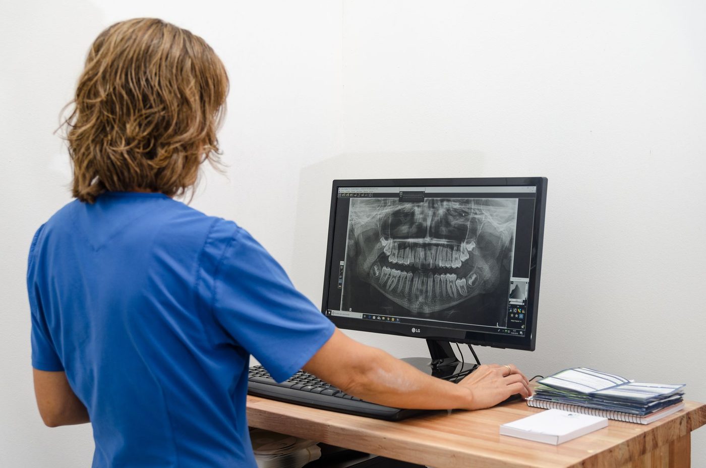 Profesional de Odonto Imágenes analizando una radiografía panorámica en pantalla